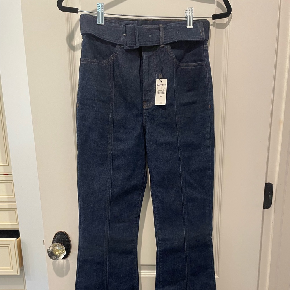 NEW with tags. Express women’s dark blue flare jeans with belt. Size 2R